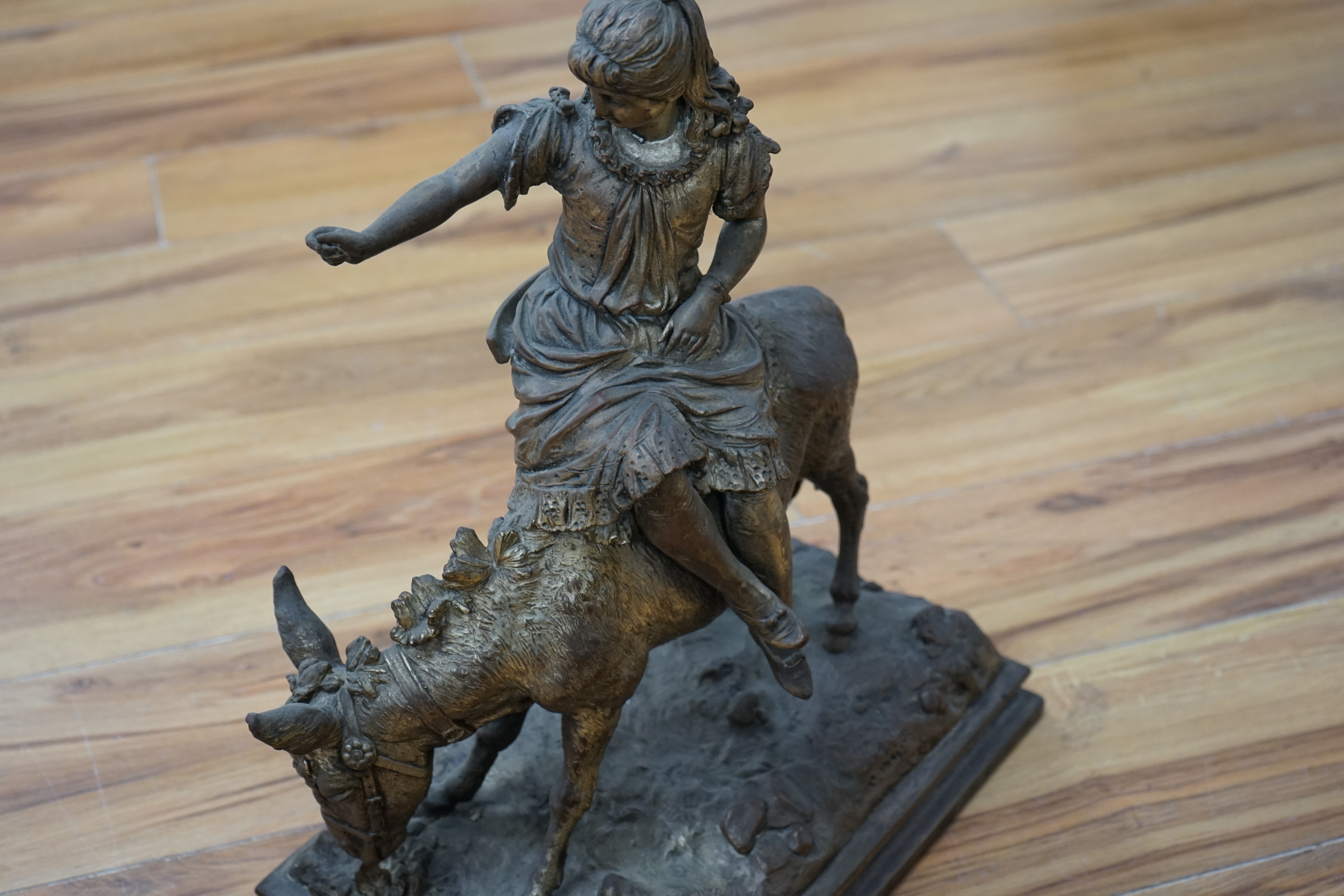 A silvered resin figure of a girl on a donkey, 45cm high. Condition - poor